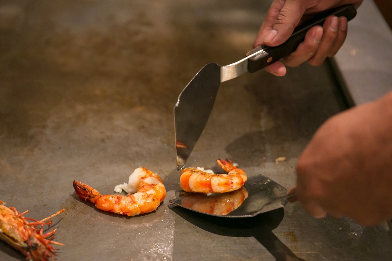 Chef cooking prawn on hibachi